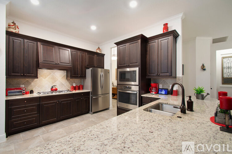 A kitchen with dark wood cabinets and granite countertops.