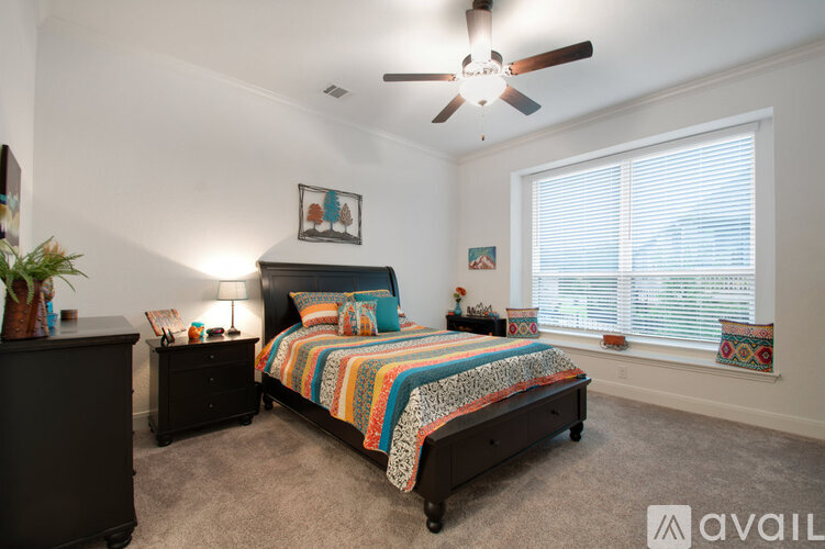 A bedroom with a bed, nightstand, and a ceiling fan.