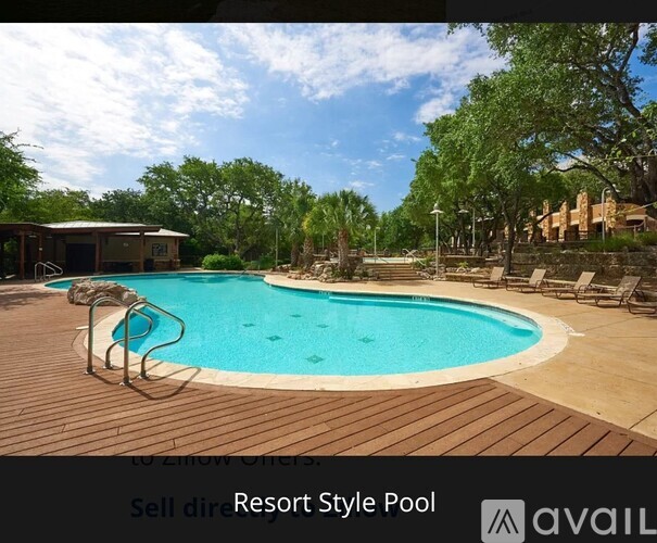 A pool surrounded by trees and chairs.
