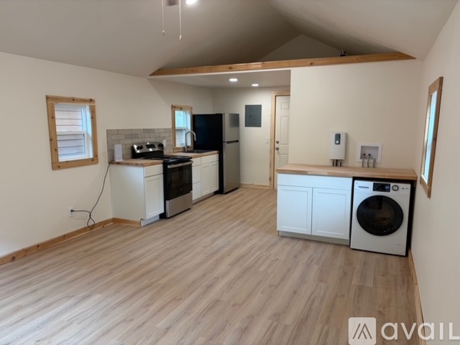 A kitchen with wooden floors and white appliances.