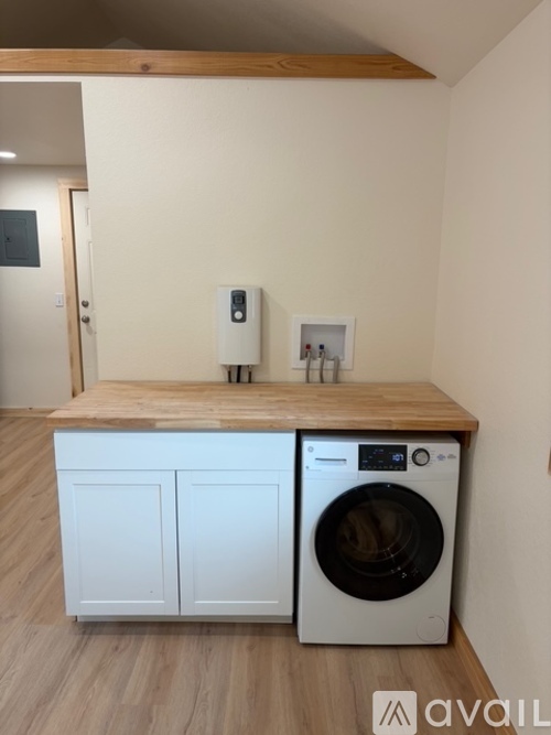 A washing machine is sitting on a wooden counter in a room.