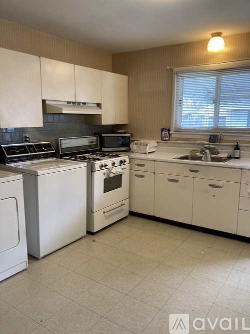 A kitchen with white appliances and cabinets.