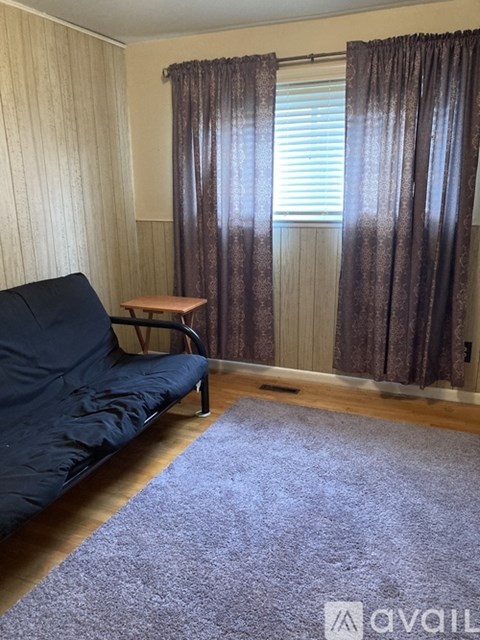 A living room with a blue sofa and a small wooden table.
