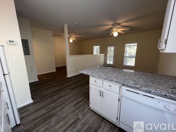 A kitchen with white cabinets and a granite countertop.
