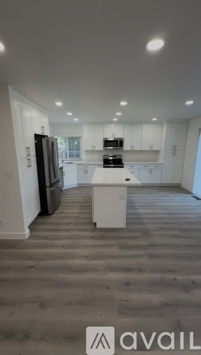 A modern kitchen with white cabinets and a central island.