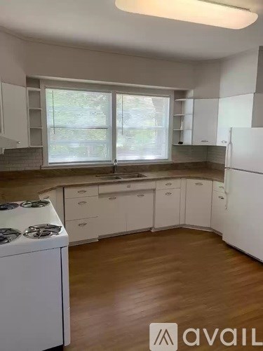 A kitchen with white cabinets and a white dishwasher.