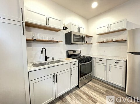 A kitchen with white cabinets and appliances.