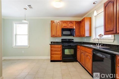 A kitchen with wooden cabinets and black appliances.