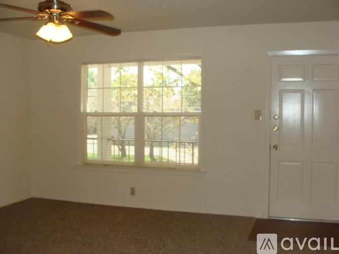 A room with a ceiling fan and a door.
