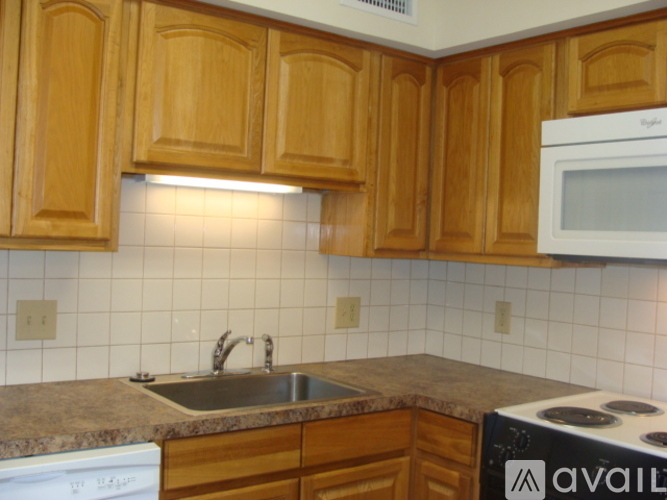 A kitchen with wooden cabinets and a white dishwasher.