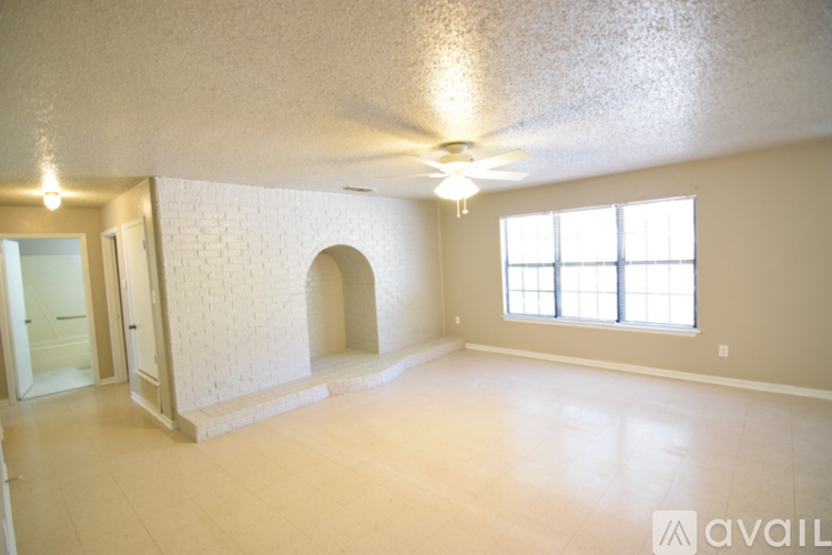 A spacious room with a window and a door leading to another room.