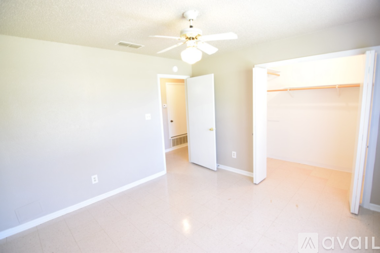 A room with a ceiling fan and two doors.