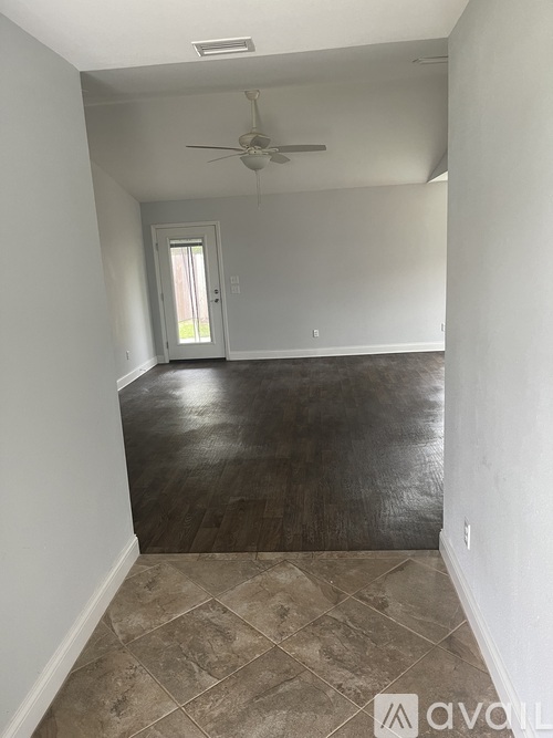 A room with a ceiling fan and tile flooring.