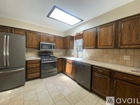 A kitchen with wooden cabinets and a tile floor.