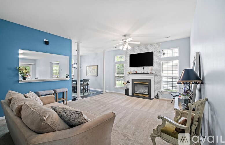 A living room with a couch, a fireplace, and a television.