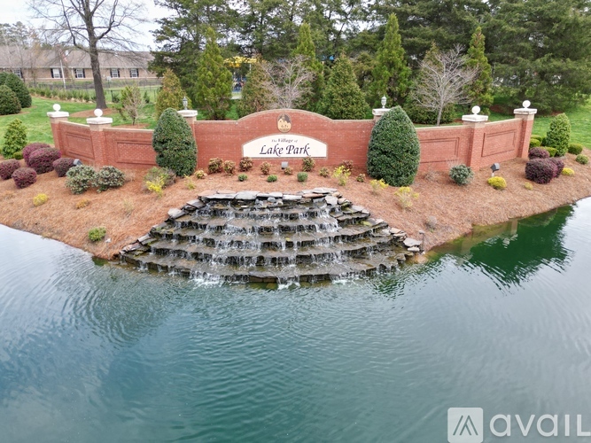 Lake Park sign in front of a waterfall and trees.