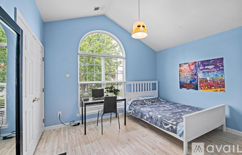 A bedroom with blue walls and a white bed.