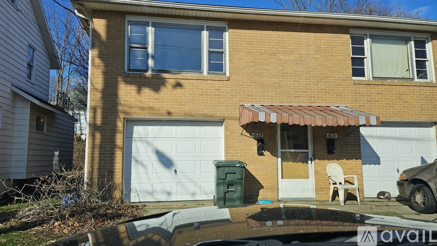 A house with a garage and a car parked in front.