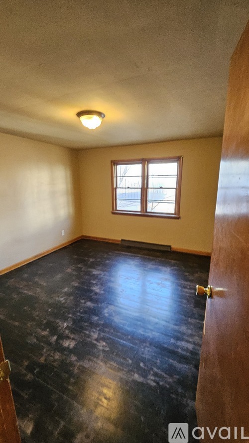 A room with a wooden floor and a window.