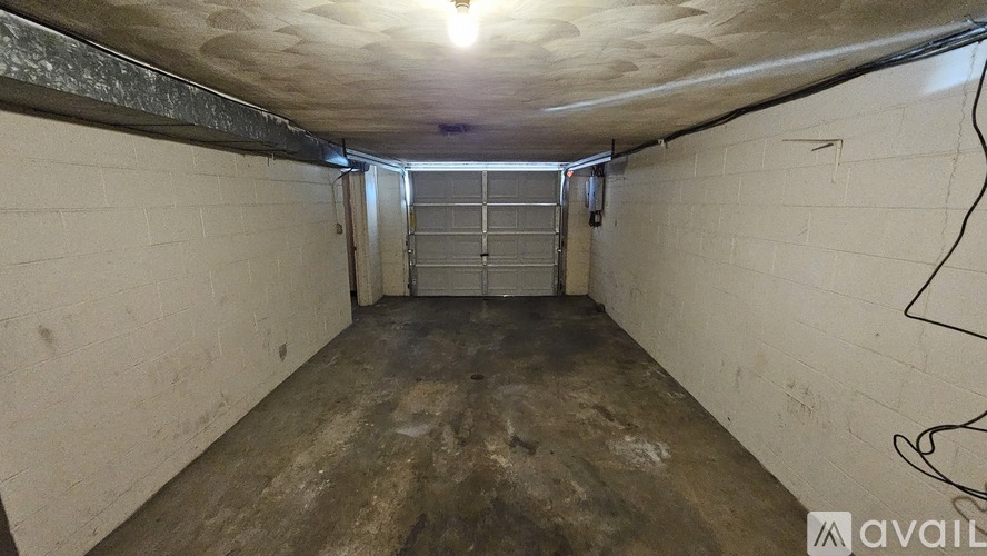 A spacious, unfinished basement with a concrete floor and walls.