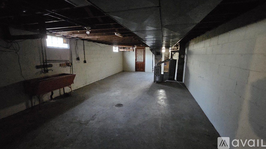 A large, empty basement with concrete floors and walls.