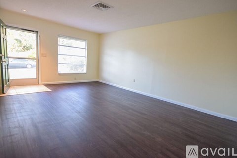 A room with wooden flooring and a window.