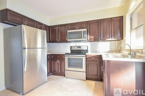 A kitchen with a stainless steel refrigerator, microwave, oven, and sink.