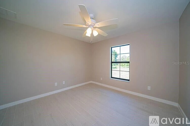 A room with a ceiling fan and a window.