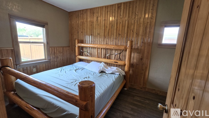 A bedroom with a wooden bed and a window.