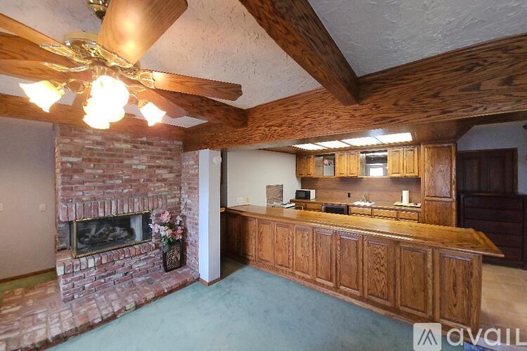 A room with a brick fireplace and a wooden floor.