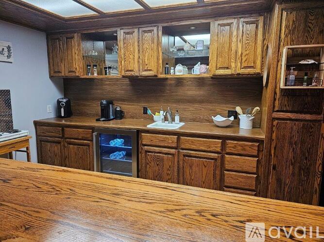 A kitchen with wooden cabinets and a wooden table.