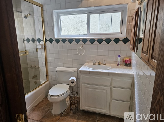 A bathroom with a toilet, sink, and a window.