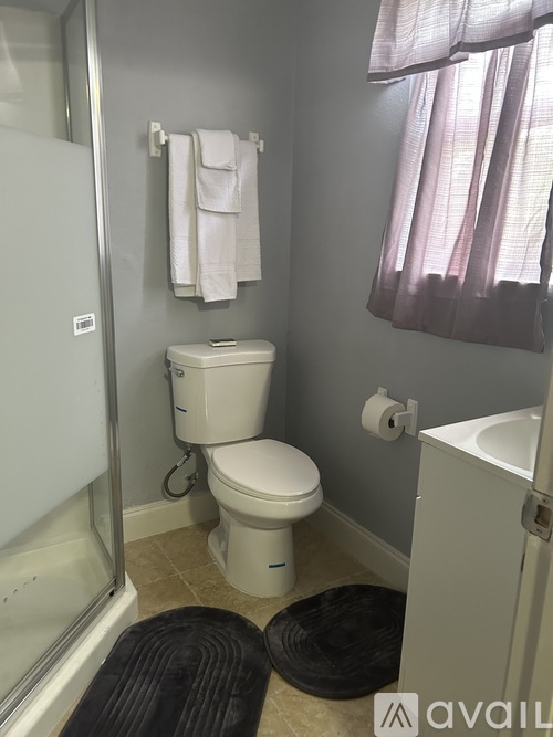 A bathroom with a toilet, sink, and shower.