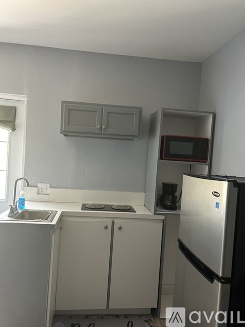 A kitchen with a sink, stove, and refrigerator.