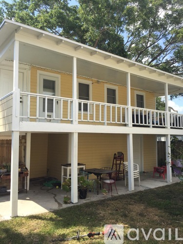 A yellow house with a white porch.