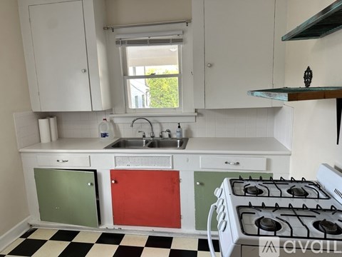 A kitchen with a white stove and a checkered floor.