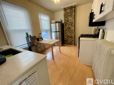 A kitchen with a white counter top and a refrigerator.