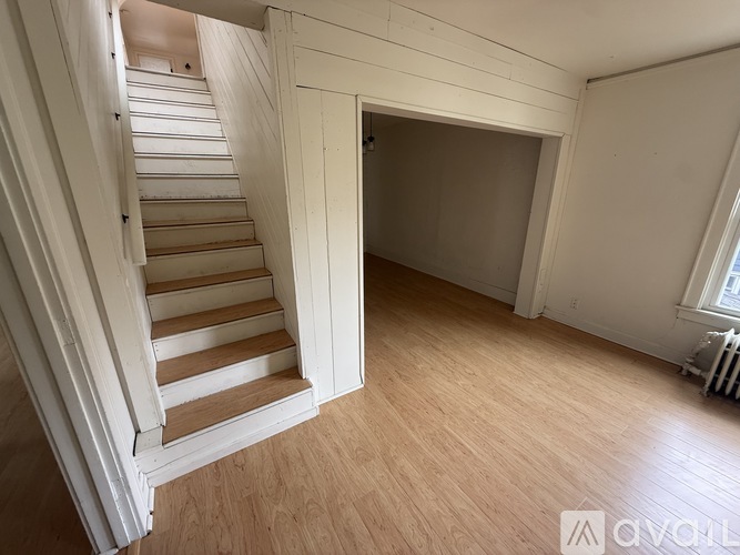 A room with wooden floors and a staircase.