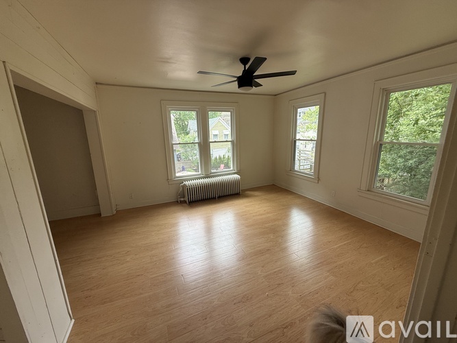 A room with wooden flooring and a ceiling fan.
