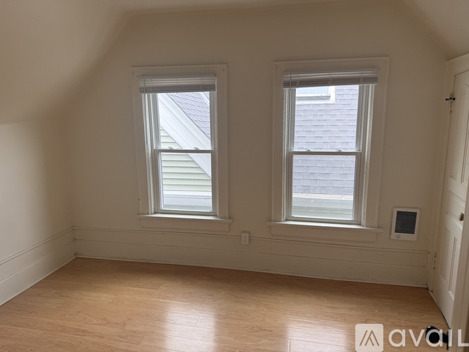 A room with two windows and wooden flooring.