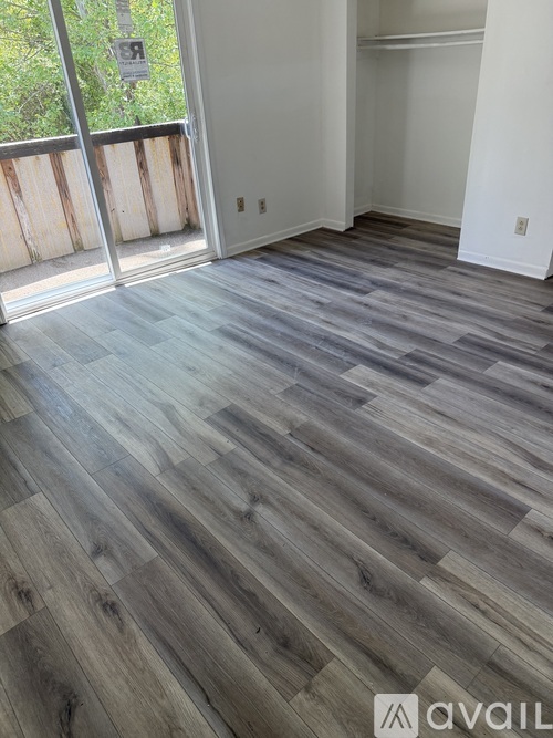 A room with wooden flooring and a sliding glass door.