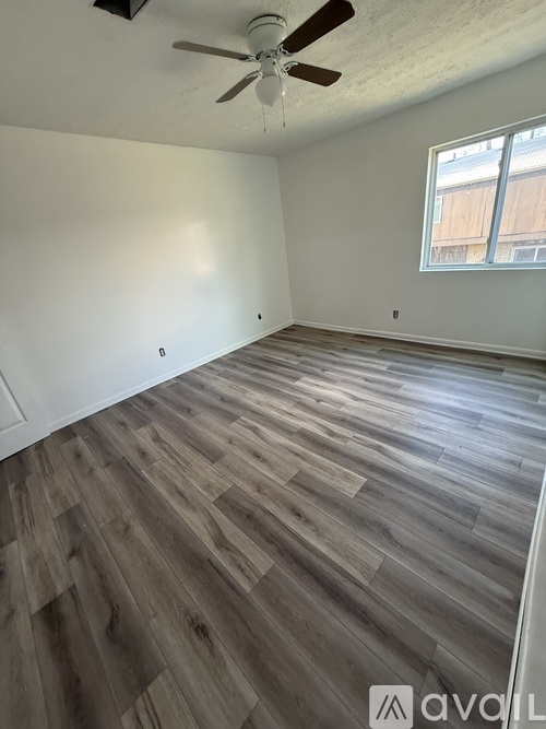 A room with wooden flooring and a ceiling fan.