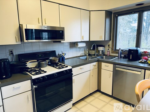 A kitchen with white cabinets and black appliances.