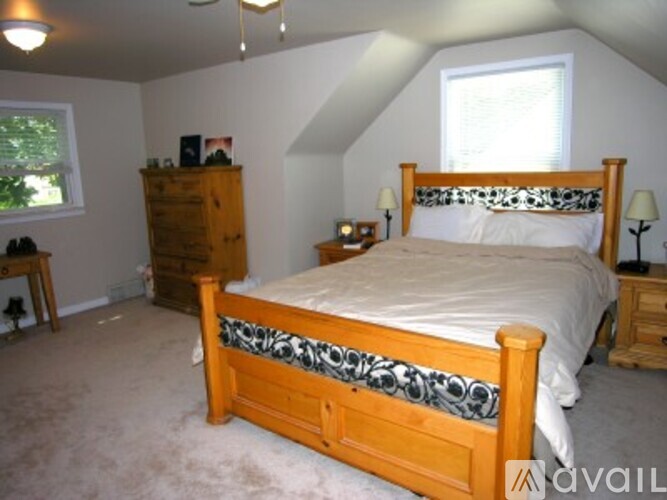 A bedroom with a bed, dresser, and window.