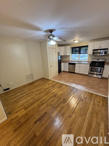 A kitchen with wooden floors and white walls.