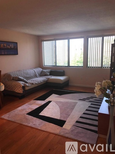 A bedroom with a bed and a couch with a pillow and a blanket on it.