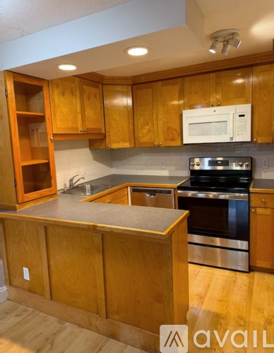 A kitchen with wooden cabinets and a stainless steel oven.