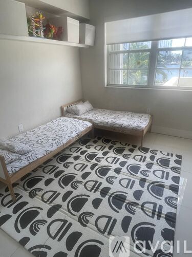 A bedroom with a bed and a rug with a pattern on it.