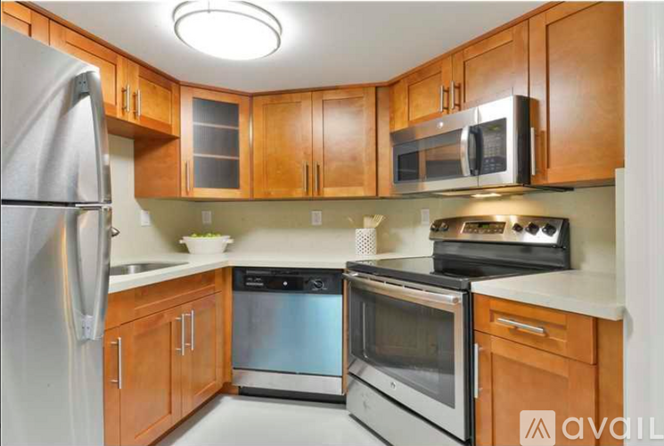 A kitchen with wooden cabinets and stainless steel appliances.