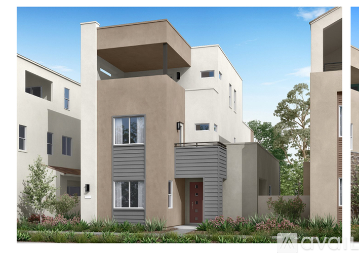 A modern house with a red door and a balcony.